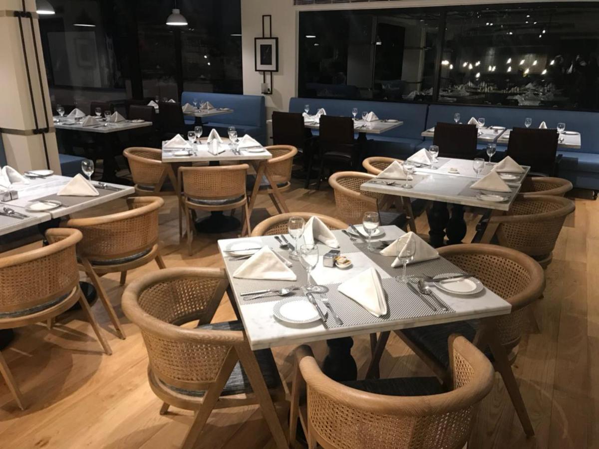 a dining room with tables and chairs in a restaurant at Radisson Hotel Shimla in Shimla