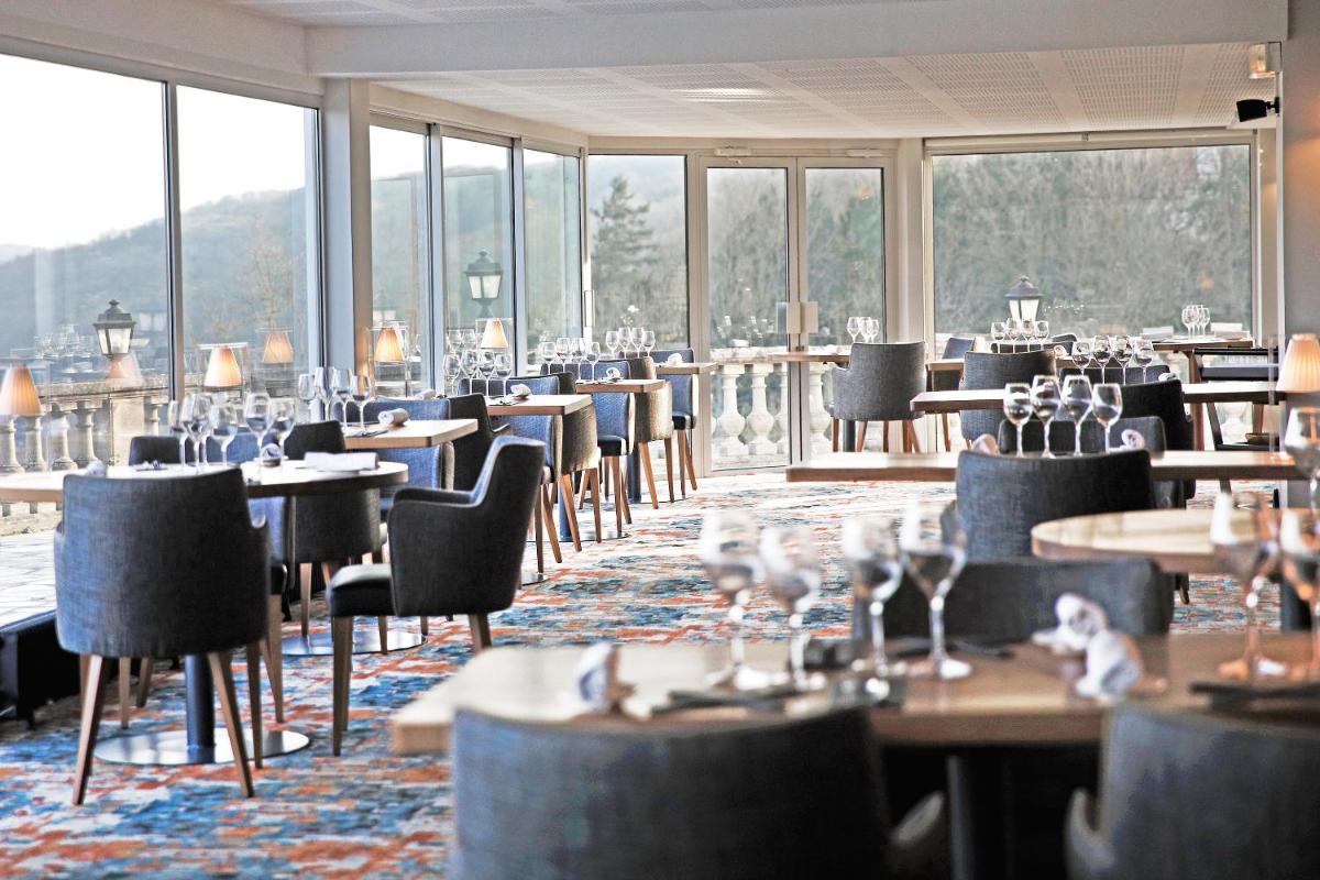 une salle à manger avec tables, chaises et fenêtres dans l'établissement Domaine De La Corniche, à Rolleboise