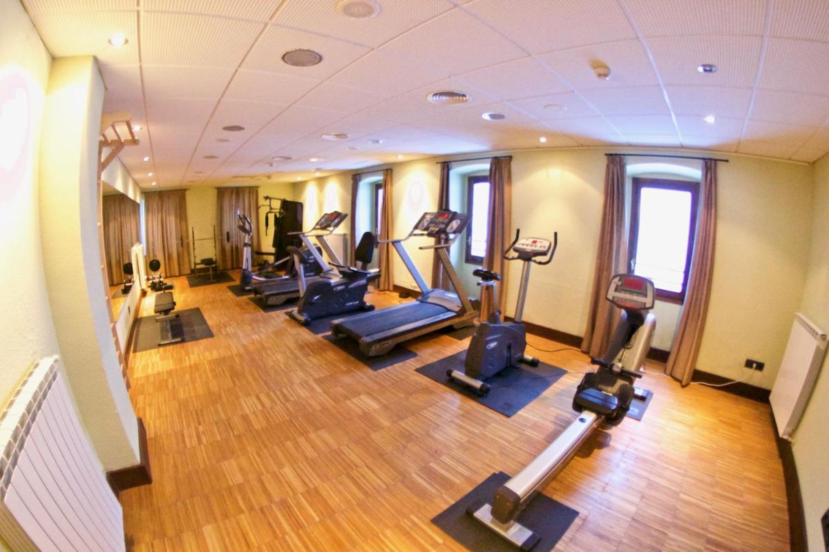 un gimnasio con varias cintas de correr y máquinas elípticas en Hotel Santa Cristina Petit Spa, en Canfranc-Estación