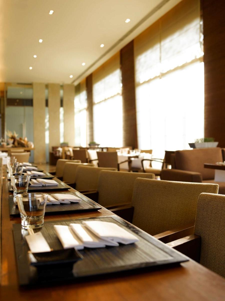 a dining room with a long table and chairs at Hyatt Hyderabad Gachibowli in Hyderabad +168 photos