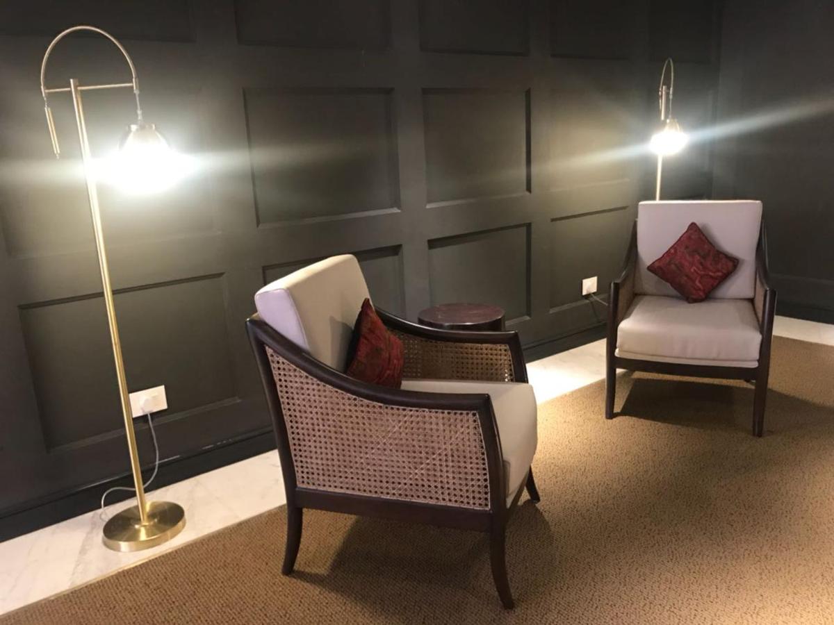 two chairs and a lamp in a living room at Radisson Hotel Shimla in Shimla