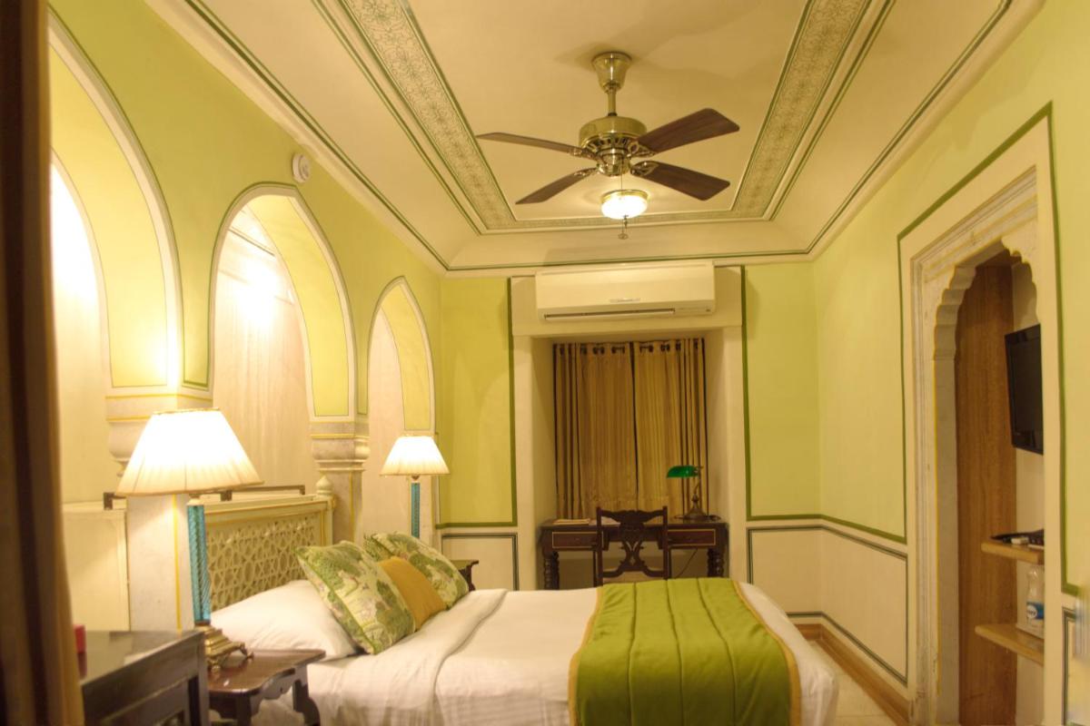 a bedroom with two beds and a ceiling fan at Royal Heritage Haveli - By Leisure Hotels in Jaipur