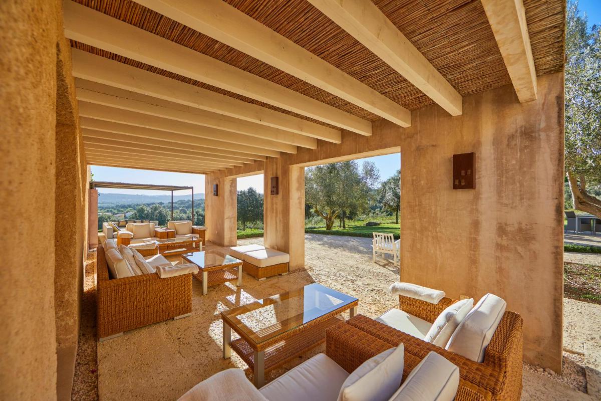 Una sala de estar al aire libre con sillas y mesas blancas. en Son Penya Adults Only Petit Hotel & Spa, en Sant Llorenç des Cardassar