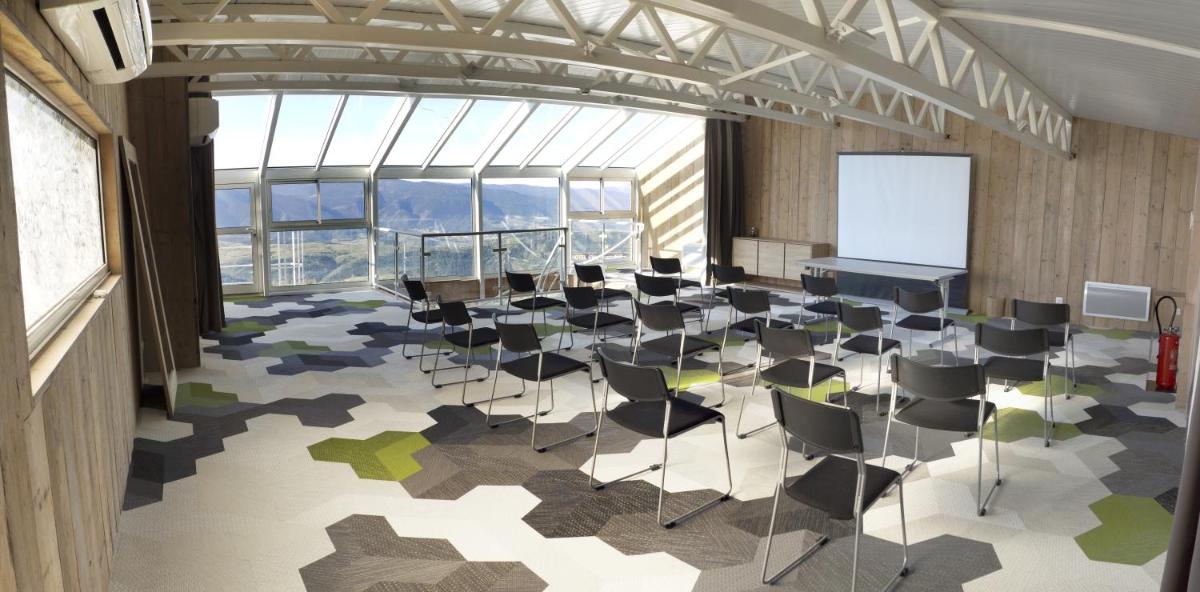 une salle de conférence avec des chaises, un podium et un écran dans l'établissement Hôtel Le Grand Tétras, à Font-Romeu 60 autres photos