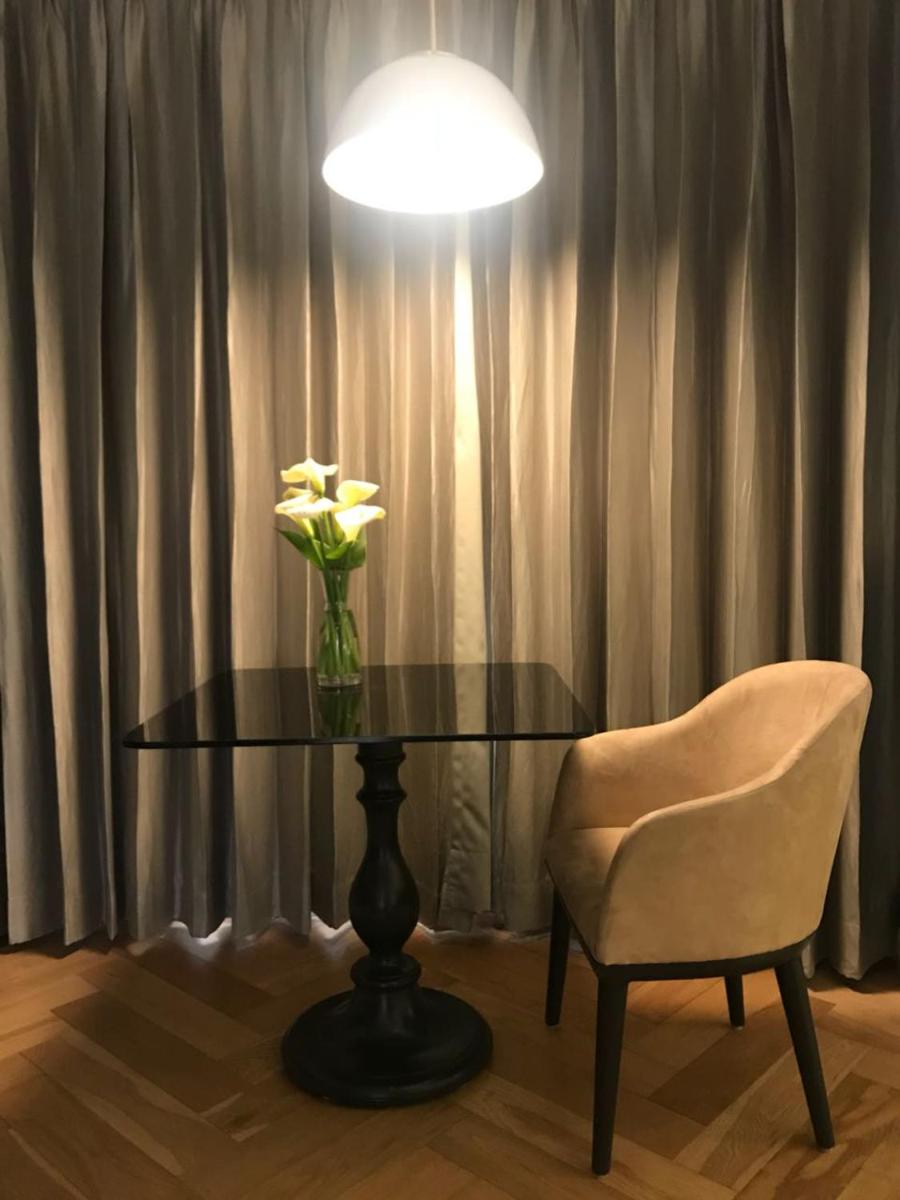 a table with a vase of flowers and a chair at Radisson Hotel Shimla in Shimla