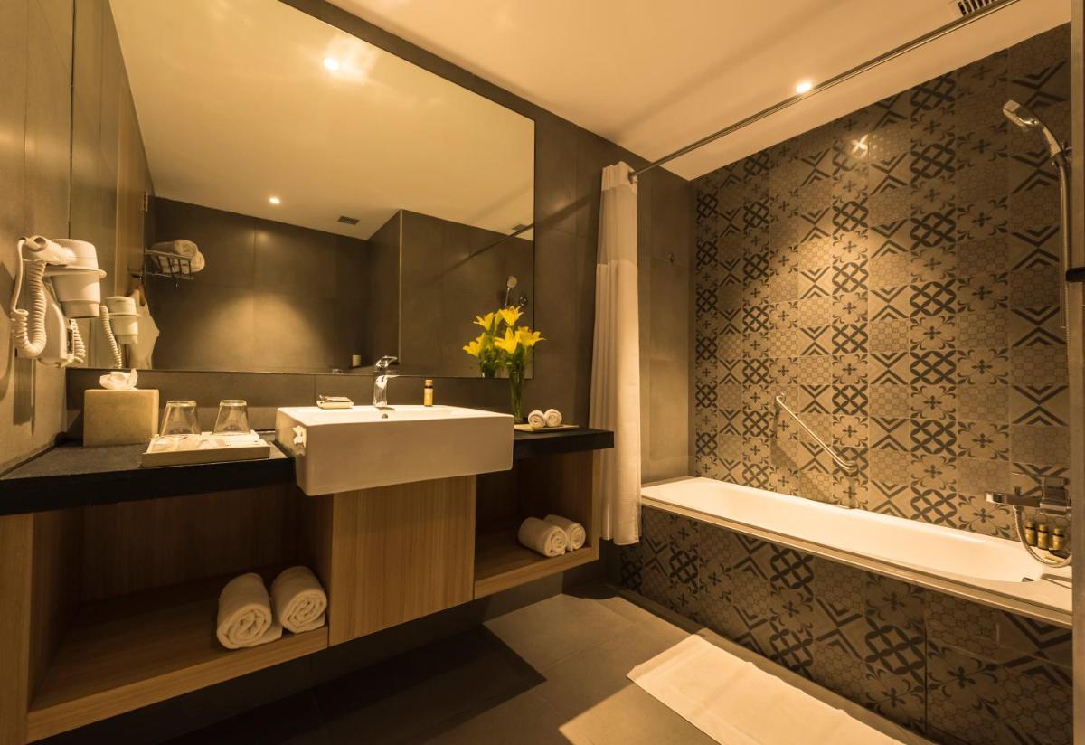 a bathroom with a sink and a bath tub at Grand Mercure Mysore - An Accor Brand in Mysore