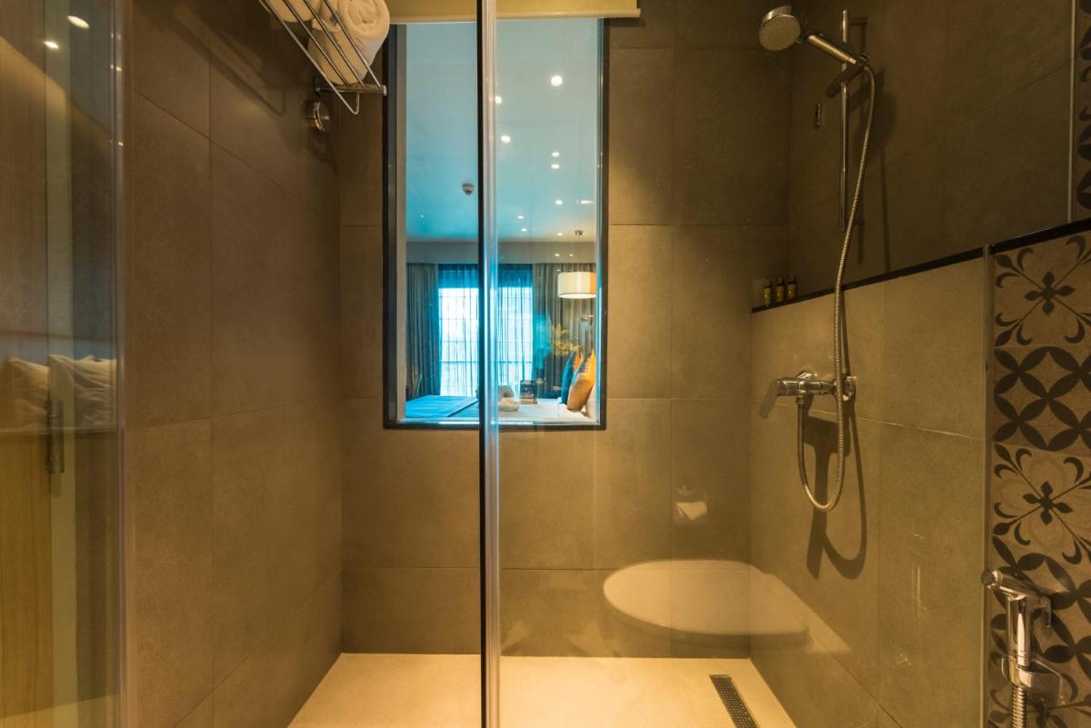 a bathroom with a glass shower with a sink at Grand Mercure Mysore - An Accor Brand in Mysore