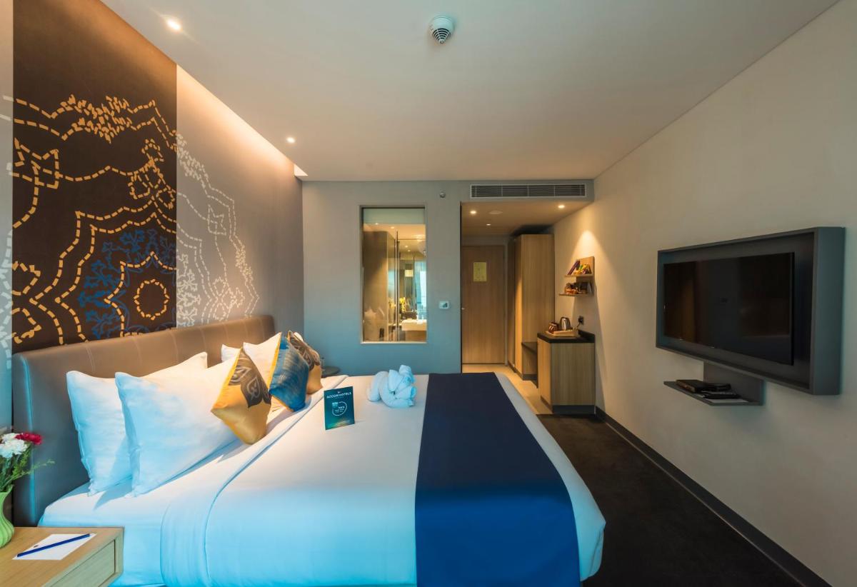 a hotel room with a large bed and a flat screen tv at Grand Mercure Mysore - An Accor Brand in Mysore