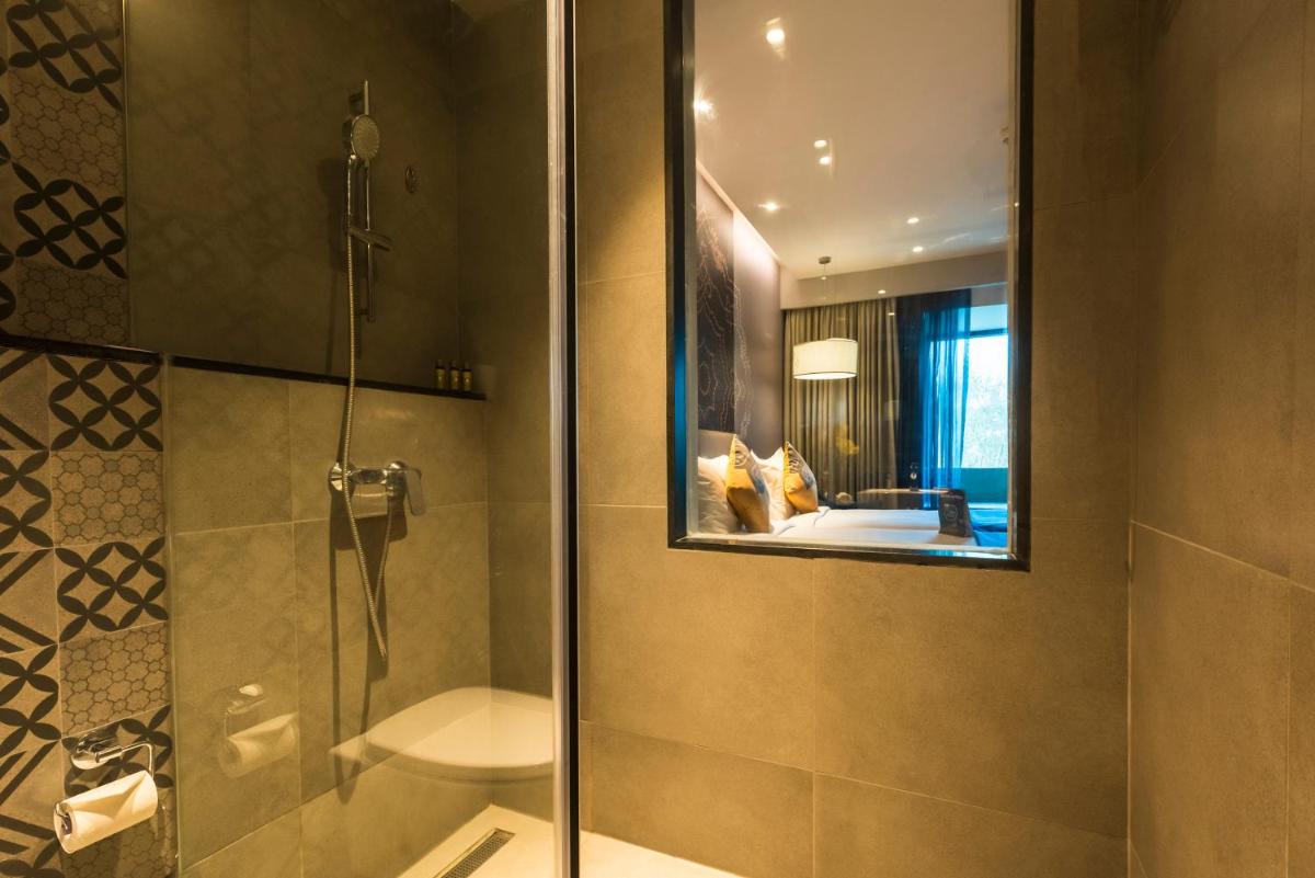a bathroom with a shower and a mirror at Grand Mercure Mysore - An Accor Brand in Mysore