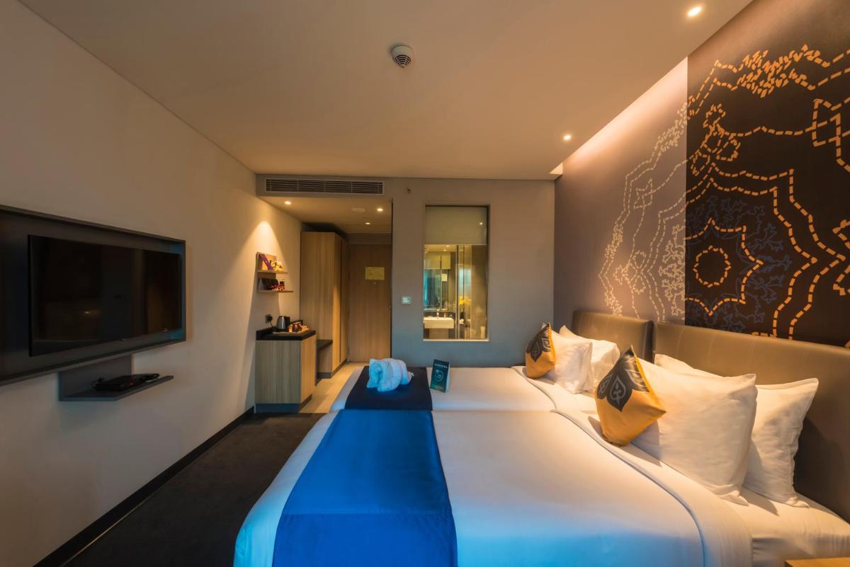 a hotel room with a large bed with a television at Grand Mercure Mysore - An Accor Brand in Mysore