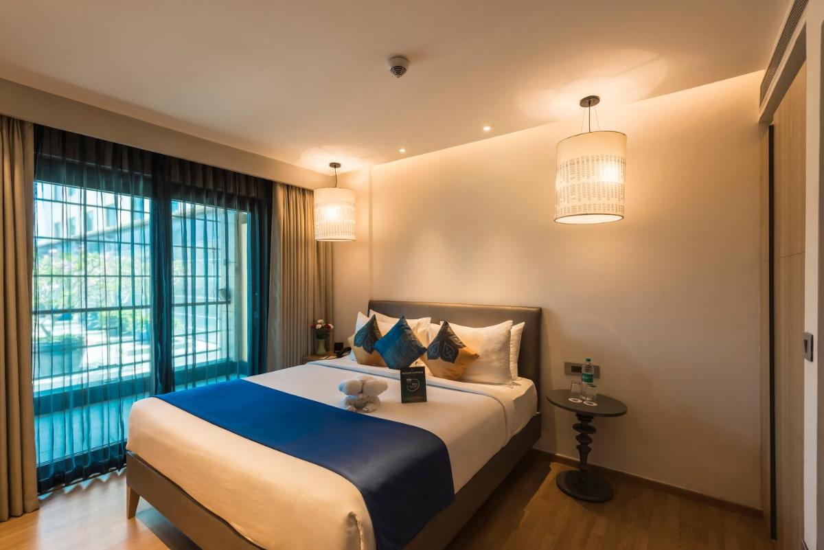 a bedroom with a large bed and a large window at Grand Mercure Mysore - An Accor Brand in Mysore