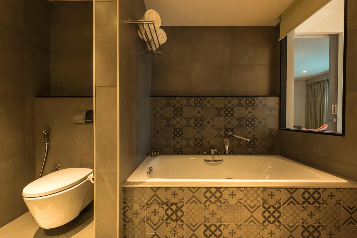 a bathroom with a toilet and a bath tub at Grand Mercure Mysore - An Accor Brand in Mysore