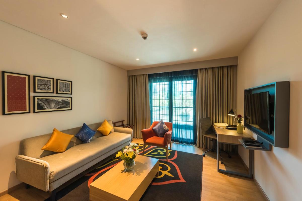 a living room with a couch and a table at Grand Mercure Mysore - An Accor Brand in Mysore