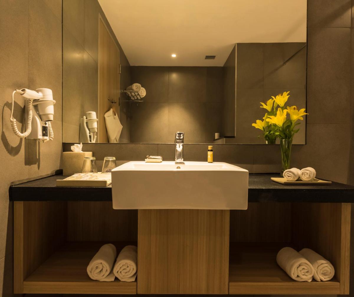 a bathroom with a sink and a mirror and towels at Grand Mercure Mysore - An Accor Brand in Mysore