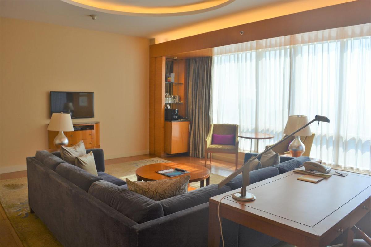 a living room with a couch and a table at Four Seasons Hotel Mumbai in Mumbai