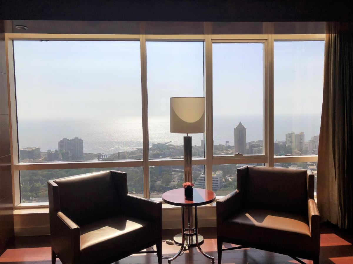two chairs and a table in front of a large window at Four Seasons Hotel Mumbai in Mumbai