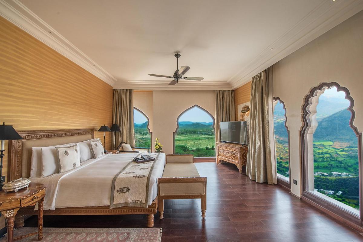 a bedroom with a bed and a large window at Fairmont Jaipur in Jaipur