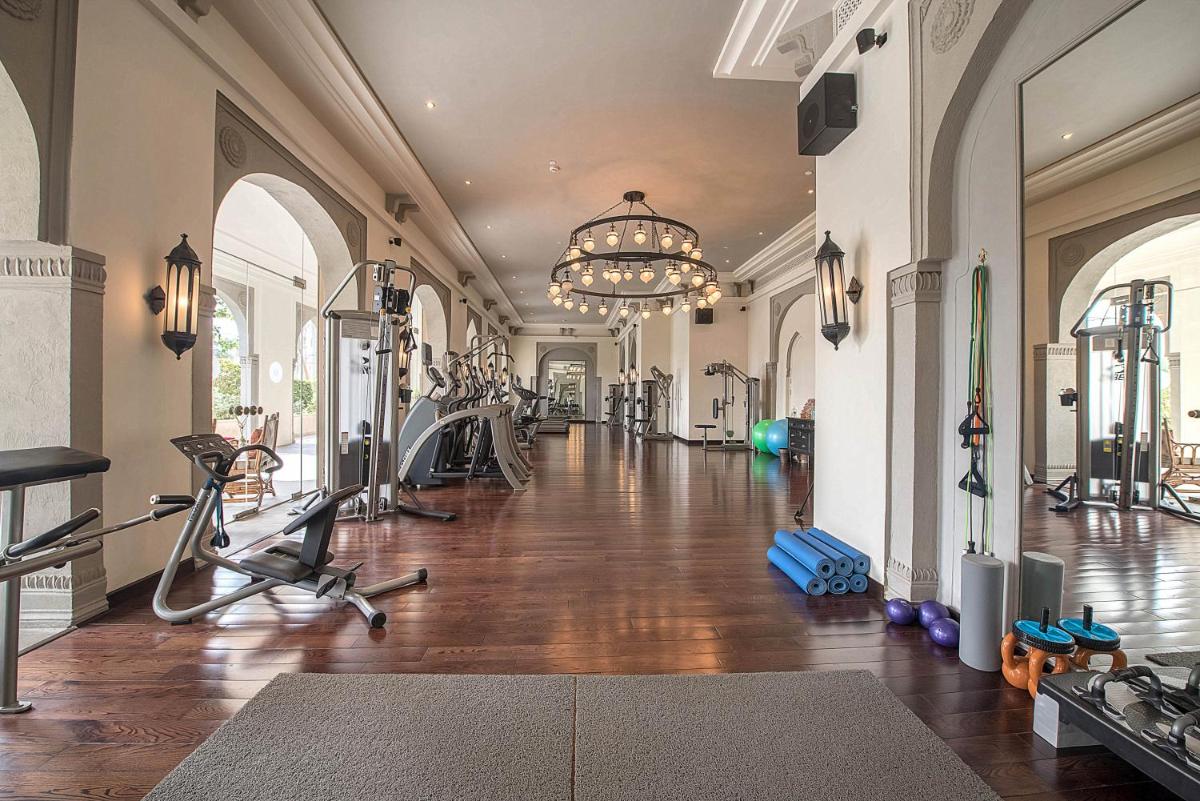 a gym with exercise bikes and a chandelier at Fairmont Jaipur in Jaipur
