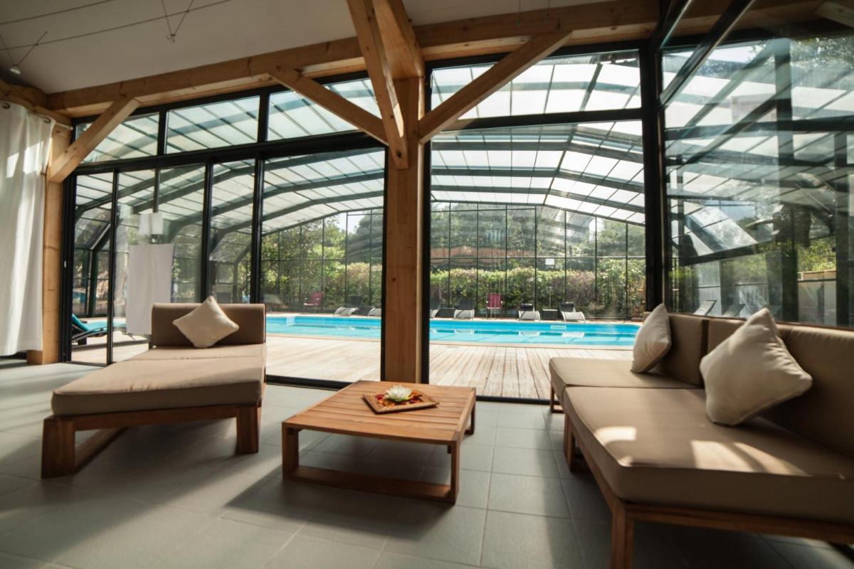 - un salon avec deux canapés et une piscine dans l'établissement Hotel Saint Paul, à Noirmoutier-en-l'lle