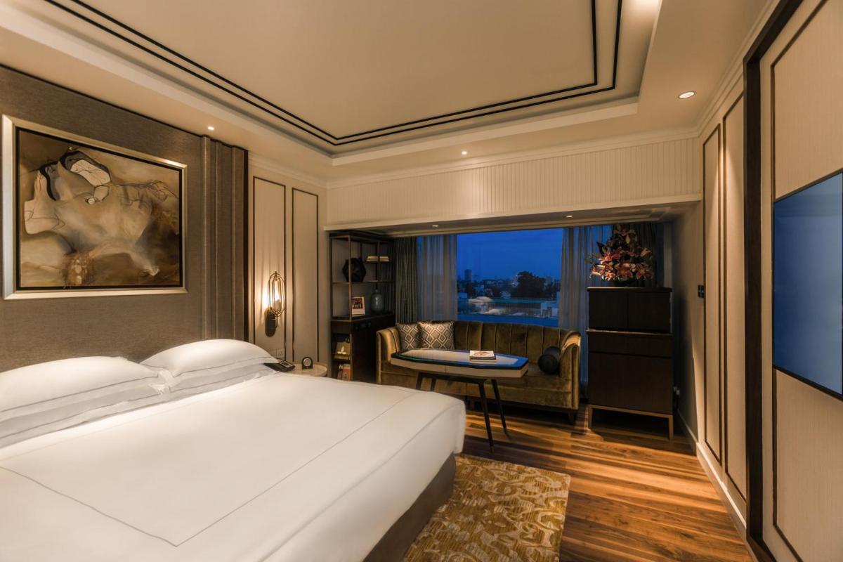 a bedroom with a bed and a desk in a room at Taj MG Road Bengaluru in Bengaluru a bedroom with a bed and a desk in a room at Taj MG Road Bengaluru in Bengaluru