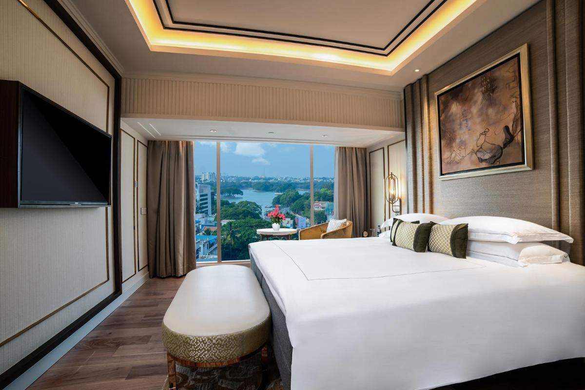 a hotel room with a large bed and a large window at Taj MG Road Bengaluru in Bengaluru a hotel room with a large bed and a large window at Taj MG Road Bengaluru in Bengaluru