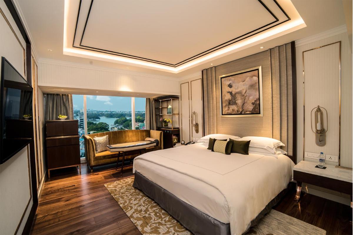 a bedroom with a large bed and a living room at Taj MG Road Bengaluru in Bengaluru a bedroom with a large bed and a living room at Taj MG Road Bengaluru in Bengaluru