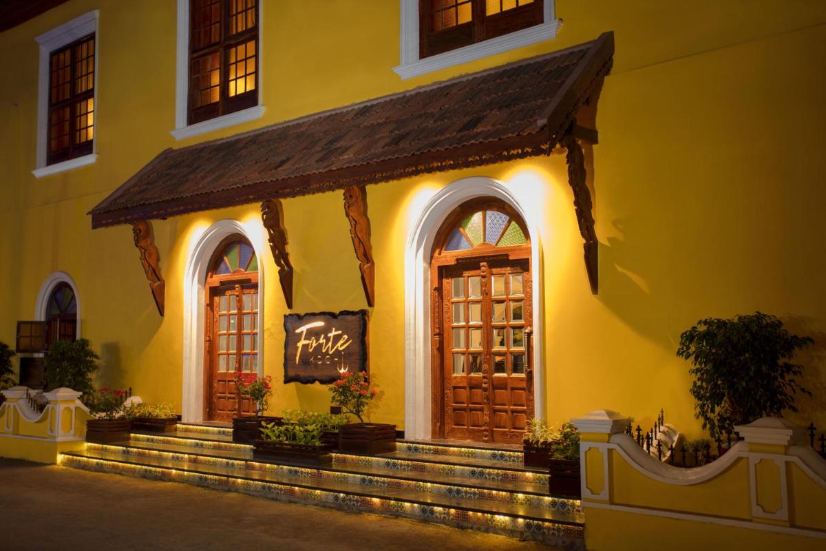 a yellow building with a cafe sign on the door at Forte Kochi in Cochin