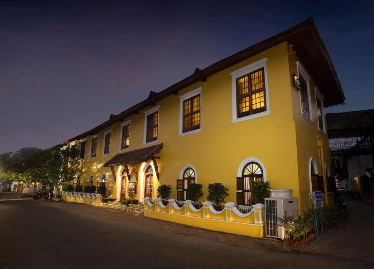 a large yellow building with windows on a street at Forte Kochi in Cochin