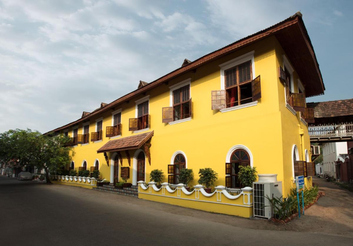 a yellow building with a fence in front of it at Forte Kochi in Cochin