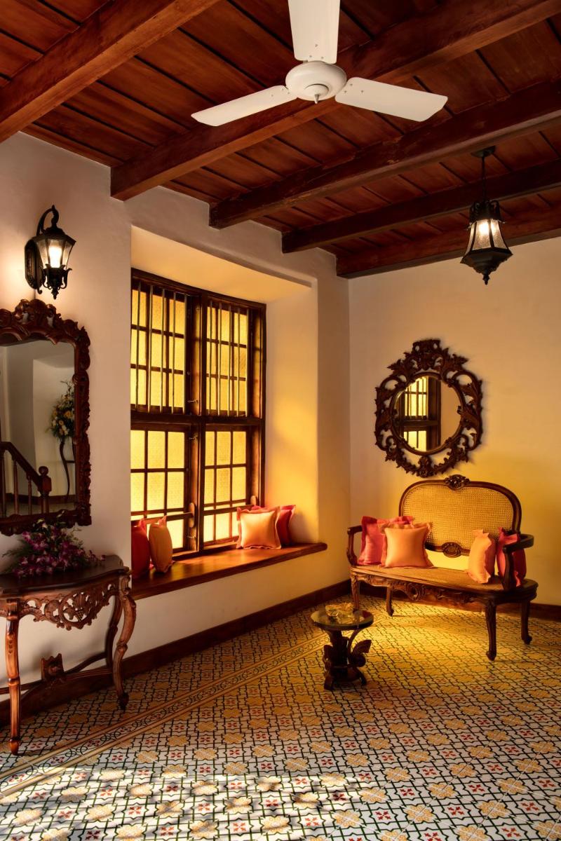 a living room with two beds and a ceiling fan at Forte Kochi in Cochin