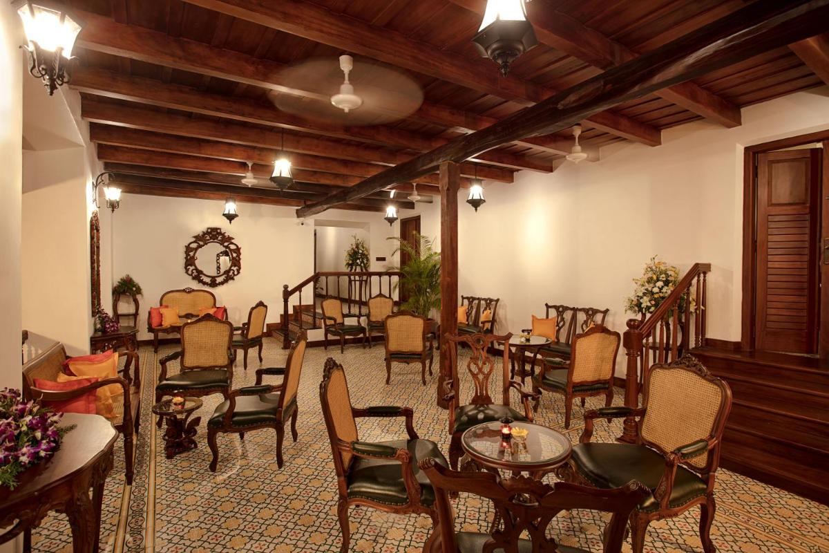 a dining room with tables and chairs and a ceiling at Forte Kochi in Cochin