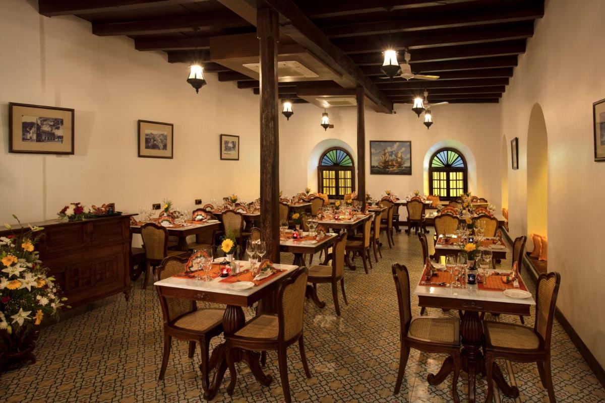 a restaurant with tables and chairs in a room at Forte Kochi in Cochin