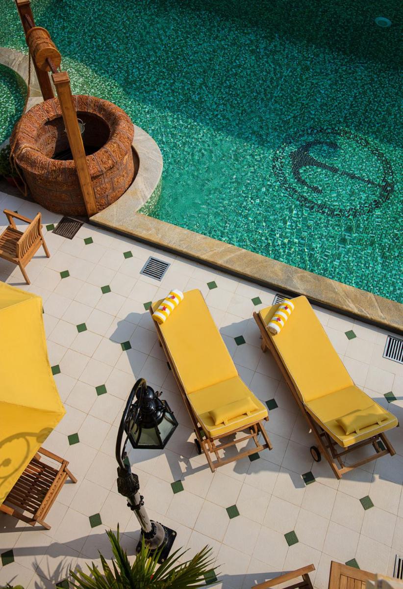 two yellow lounge chairs next to a swimming pool at Forte Kochi in Cochin