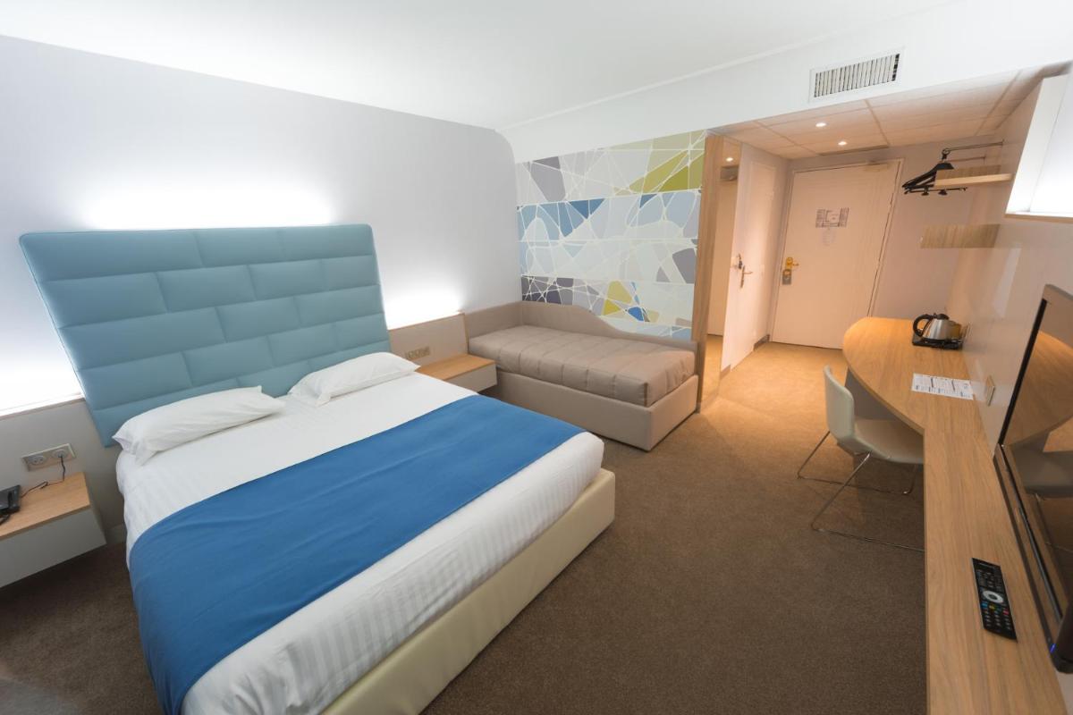 Un ou plusieurs lits dans un hébergement de l'établissement Hotel Plaza - site du Futuroscope