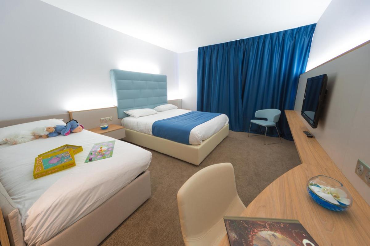 Un ou plusieurs lits dans un hébergement de l'établissement Hotel Plaza - site du Futuroscope