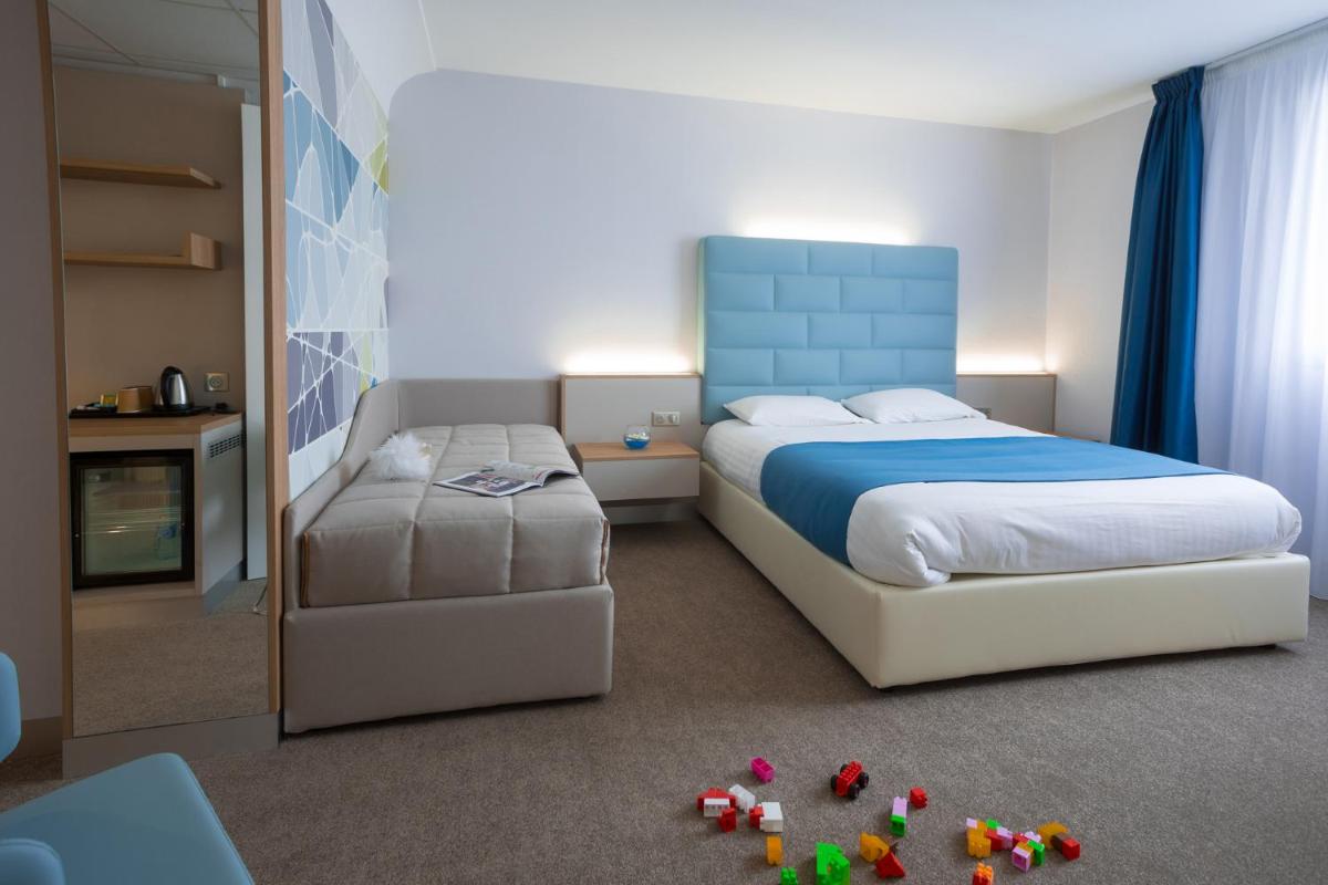 Un ou plusieurs lits dans un hébergement de l'établissement Hotel Plaza - site du Futuroscope