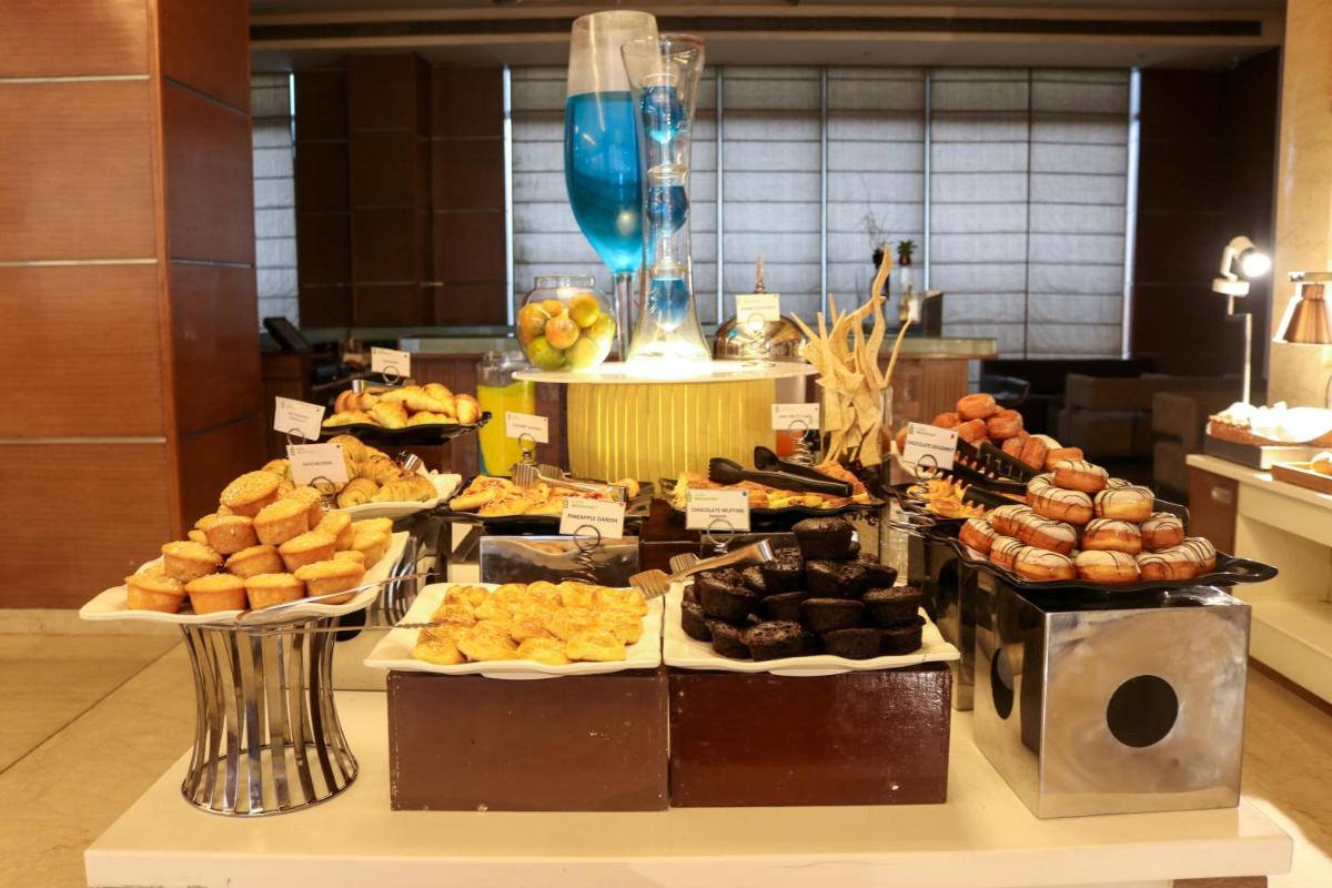 a buffet of different types of pastries on a table at Radisson Blu Hotel, Greater Noida in Greater Noida