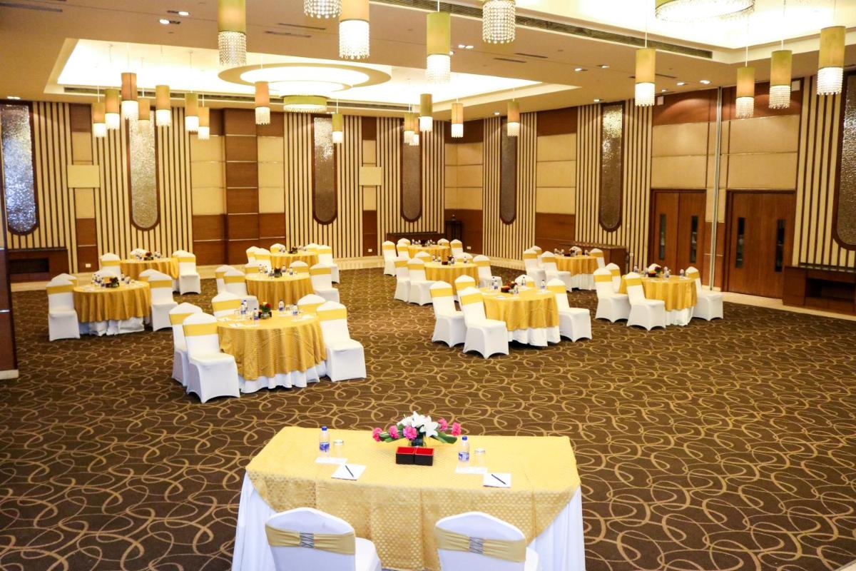 a banquet hall with yellow tables and white chairs at Radisson Blu Hotel, Greater Noida in Greater Noida