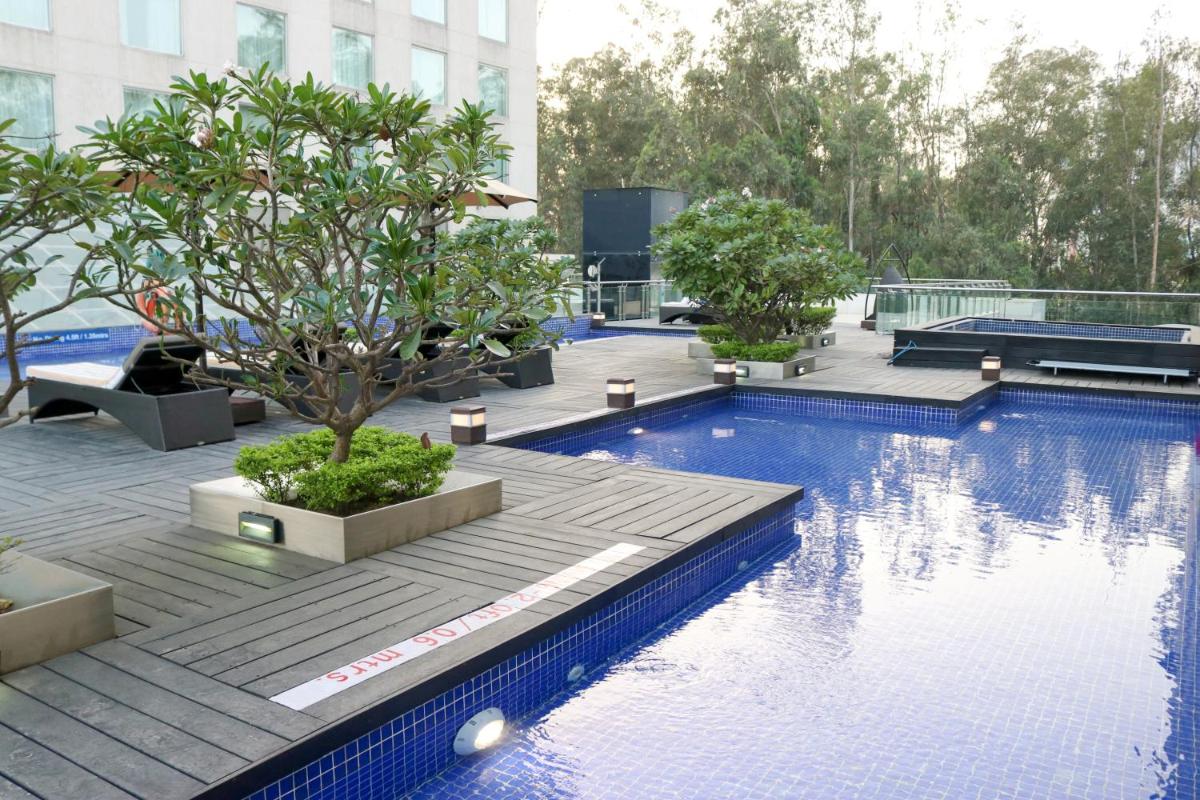 a swimming pool with trees on the roof of a building at Radisson Blu Hotel, Greater Noida in Greater Noida