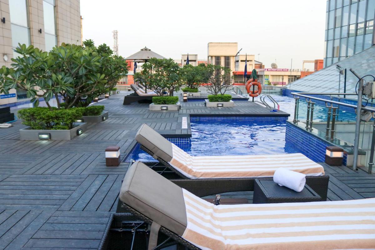 a swimming pool with two beds on a building at Radisson Blu Hotel, Greater Noida in Greater Noida