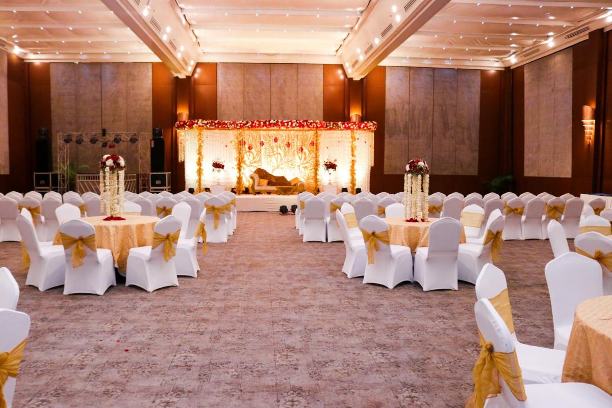 a banquet hall with white tables and white chairs at Radisson Blu Hotel, Greater Noida in Greater Noida