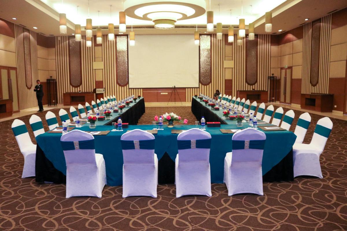 a conference room with a blue table and chairs at Radisson Blu Hotel, Greater Noida in Greater Noida