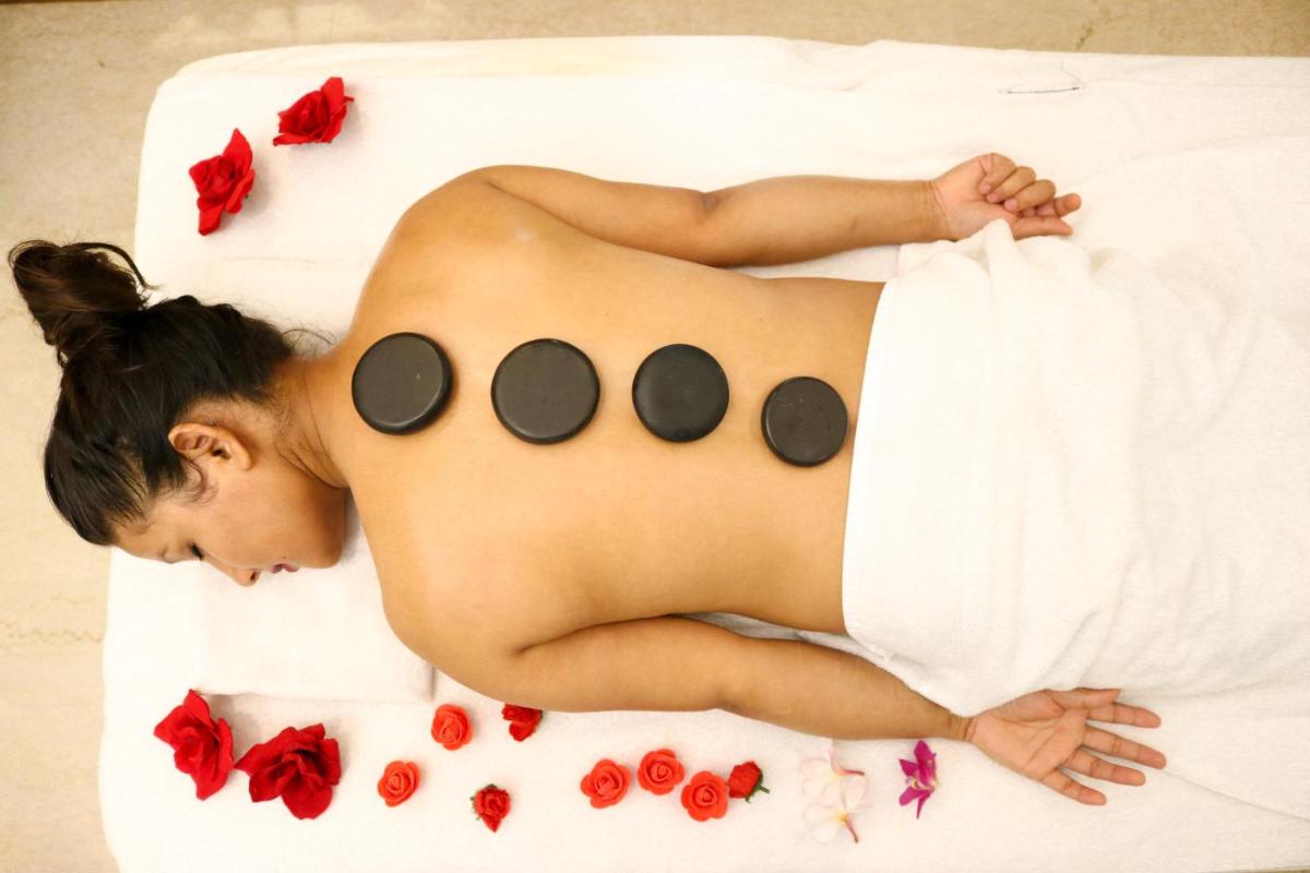 a naked woman laying in a bed with flowers at Radisson Blu Hotel, Greater Noida in Greater Noida