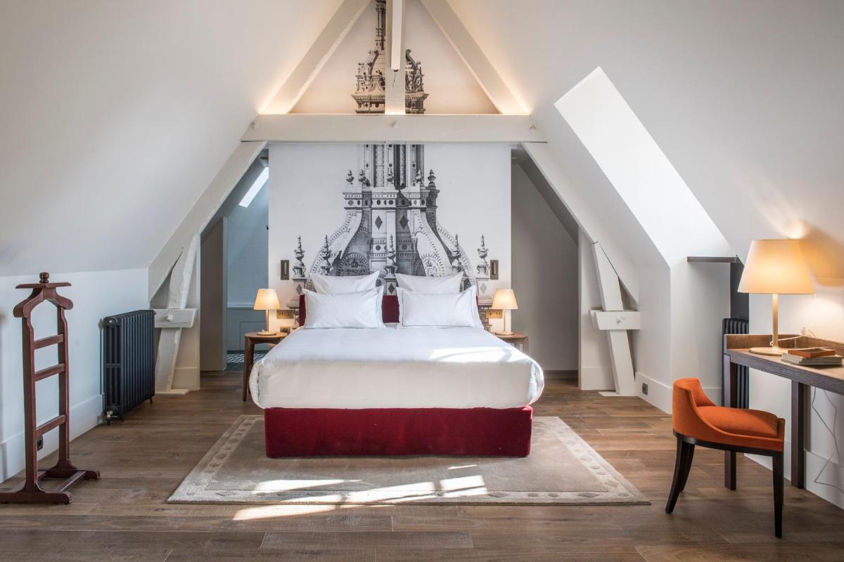une chambre avec un grand lit blanc et un escalier dans l'établissement Relais de Chambord, a Small Luxury Hotels of the World, à Chambord