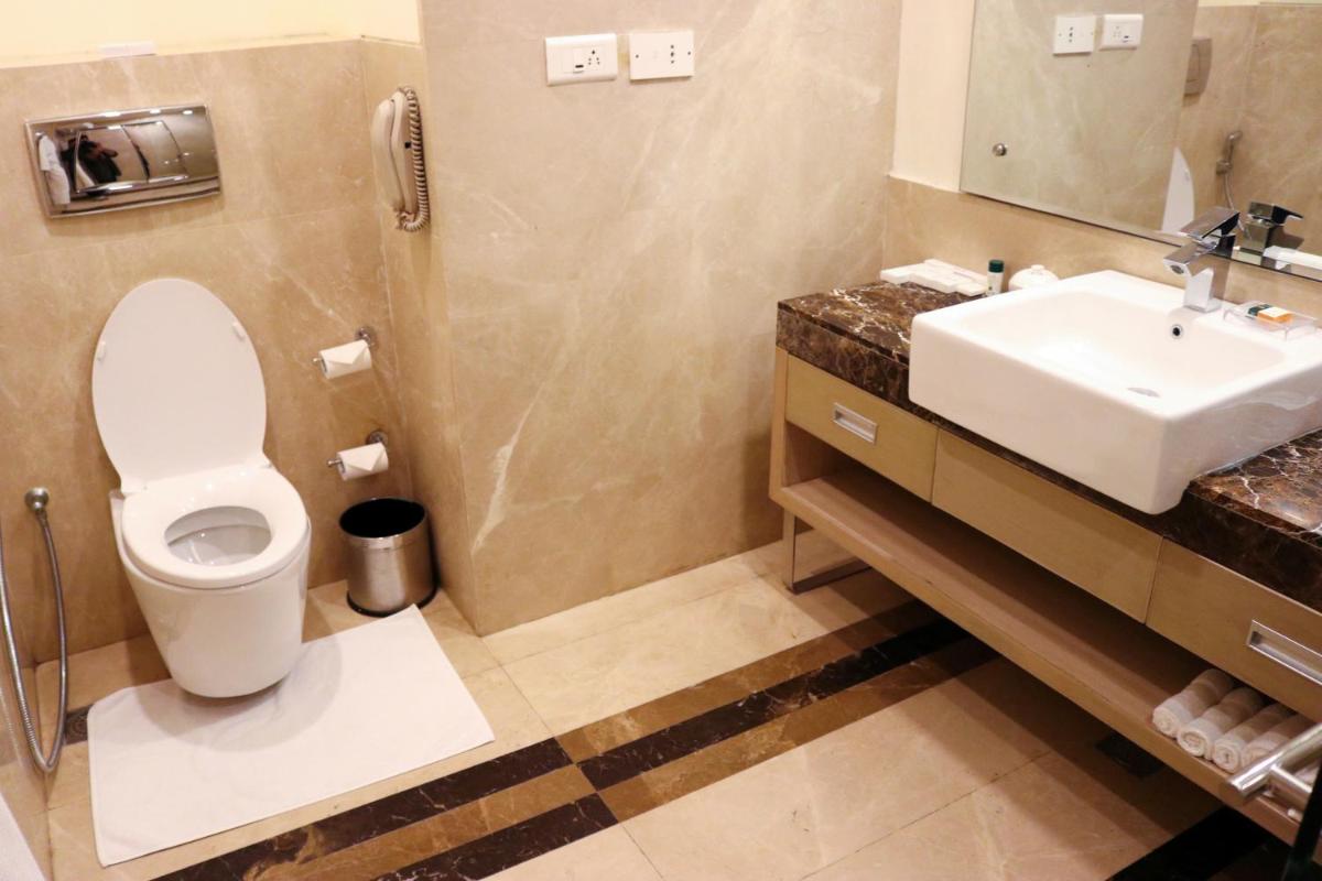 a bathroom with a toilet and a sink at Radisson Blu Hotel, Greater Noida in Greater Noida