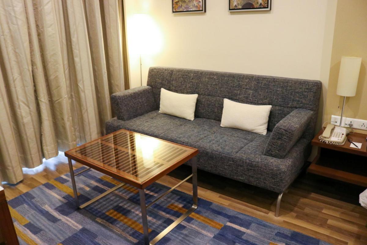 a living room with a couch and a coffee table at Radisson Blu Hotel, Greater Noida in Greater Noida