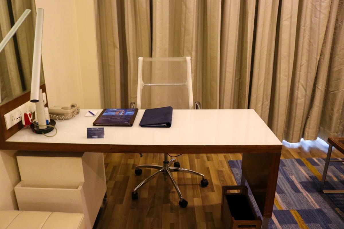 an office with a desk with a computer and a chair at Radisson Blu Hotel, Greater Noida in Greater Noida