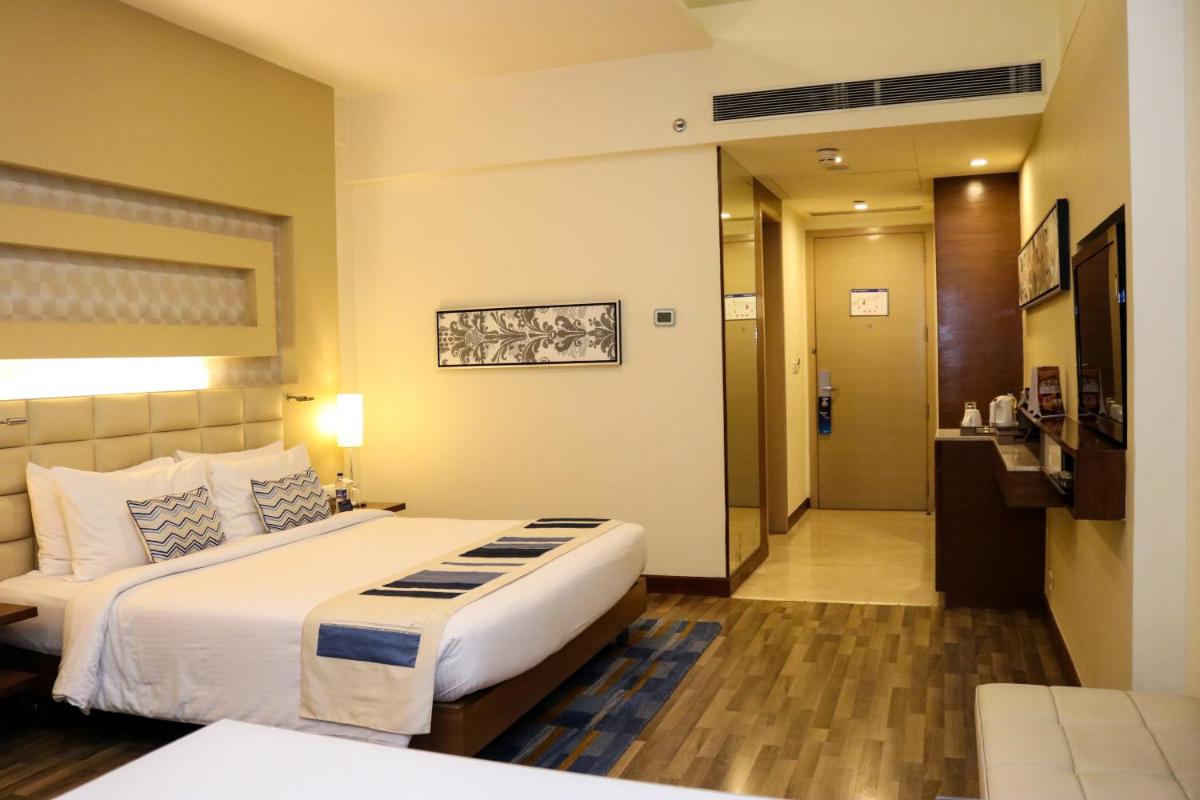 a hotel room with a large bed and a bathroom at Radisson Blu Hotel, Greater Noida in Greater Noida