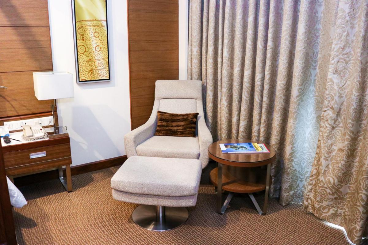a chair and a table in a hotel room at Radisson Blu Hotel, Greater Noida in Greater Noida