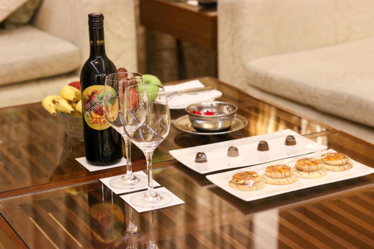 a table with two glasses and a bottle of wine at Radisson Blu Hotel, Greater Noida in Greater Noida
